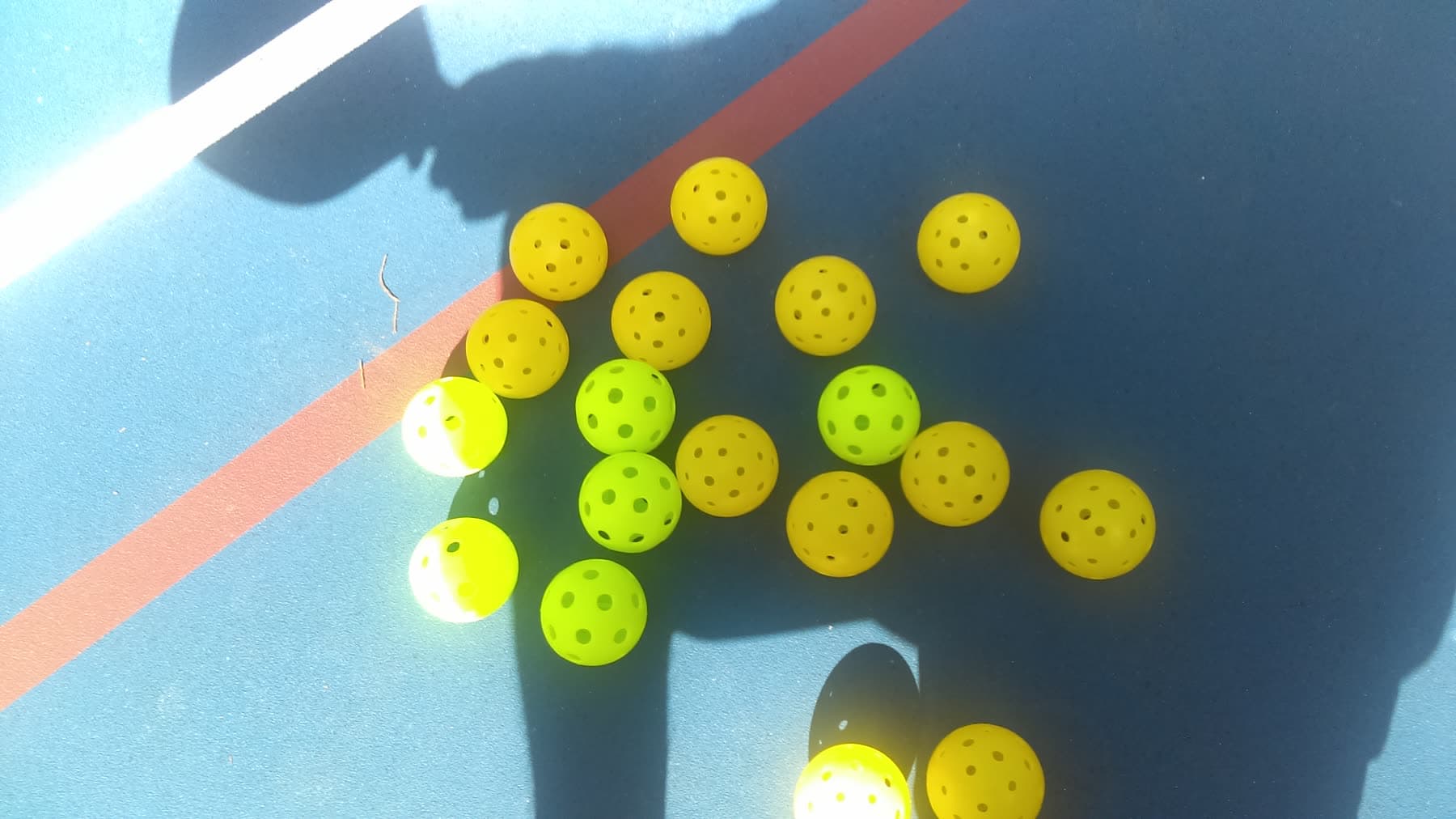Pickleballs on a blue court